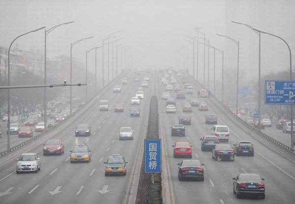 Des véhicules roulent dans le smog lourd à Beijing, le 20 février 2014. [Photo/Xinhua]