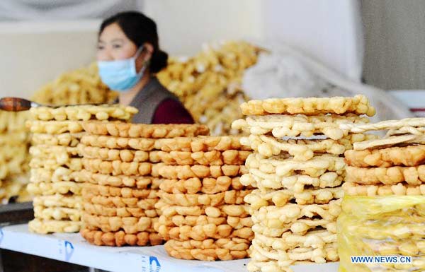 Un marchand vend du "Kasai," l'aliment traditionnel tibétain, à base de farine frit, pour l'arrivée prochaine du Nouvel An tibétain (aussi appelé «Losar»), à Lhassa, la capitale de la région autonome du Tibet au sud-ouest de la Chine, le 24 février 2014. La population de l'ethnie tibétaine s'apprête à accueillir la nouvelle année du Cheval de Bois, le 2 mars. [Photo/Xinhua] 