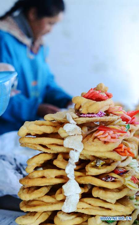 Un marchand vend du "Kasai," l'aliment traditionnel tibétain, à base de farine frit, pour l'arrivée prochaine du Nouvel An tibétain (aussi appelé «Losar»), à Lhassa, la capitale de la région autonome du Tibet au sud-ouest de la Chine, le 24 février 2014. La population de l'ethnie tibétaine s'apprête à accueillir la nouvelle année du Cheval de Bois, le 2 mars. [Photo/Xinhua] 