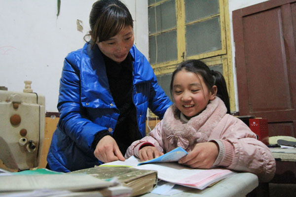 Dong Yuping, 33 ans, aide sa fille de 12 ans, Dong Luxin, pour la lecture ; la fillette est en sixième année dans une école primaire. Mme Dong loue une maison miteuse près de l'école de sa fille, qui lui coûte 5 000 Yuans par an.
