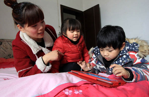 Qiuxia, 27 ans, joue avec les enfants dans le Comté de Wenxian de la ville de Jiaozuo, dans la province centrale du Henan, le 25 février 2014. Elle loue un appartement situé à proximité de l'école de son fils âgé de 6 ans et qui est en première année, afin de mieux prendre soin de lui.