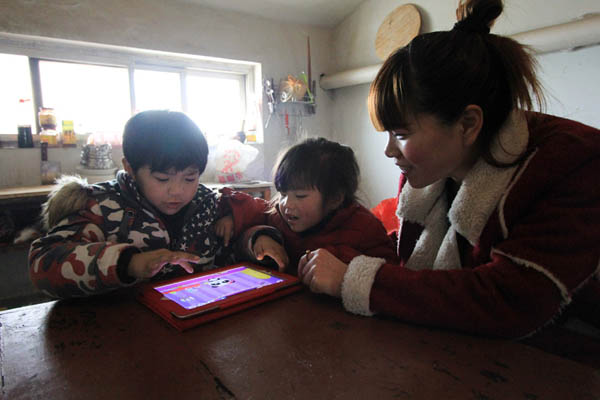 Qiuxia, 27 ans, joue avec les enfants dans le Comté de Wenxian de la ville de Jiaozuo, dans la province centrale du Henan, le 25 février 2014. Elle loue un appartement situé à proximité de l'école de son fils âgé de 6 ans et qui est en première année, afin de mieux prendre soin de lui.
