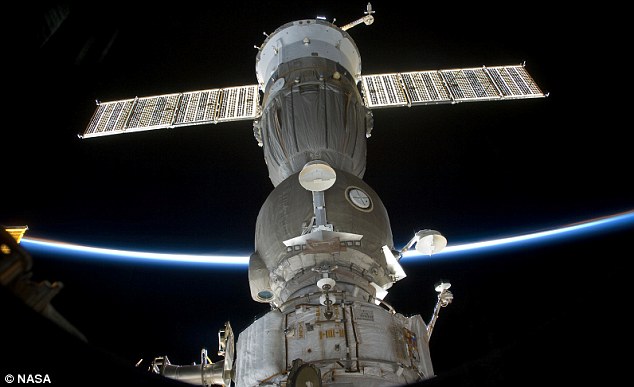 Une image du vaisseau spatial russe Soyouz amarré à l'ISS. Sur le fond de la photo, une partie de la Terre est fort visible. 
