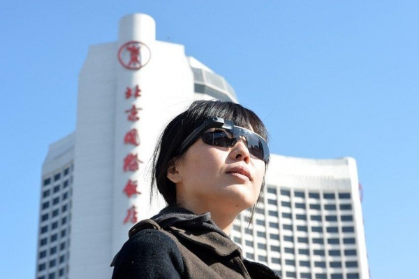 Le 1er mars, une journaliste du Quotidien du Peuple en ligne porte les lunettes Google lors d'un reportage effectué dans l'hôtel où logent les participants des deux sessions 2014.