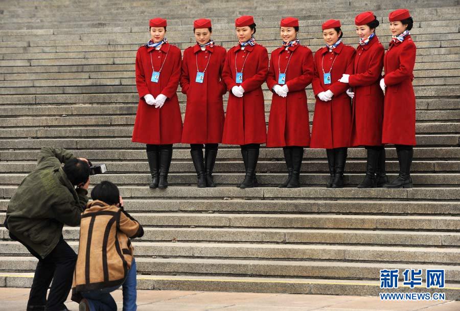 Lundi 3 mars, deux journalistes photographient des hôtesses d'accueil de la 2ème session du 12e Comité National de la CCPPC devant le Palais du Peuple à Beijing. (Xinhua/Di Zihe)