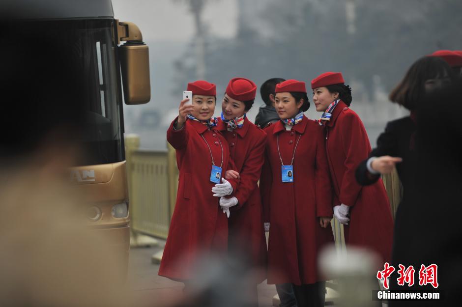 Lundi 3 mars, des hôtessess d'accueil de la 2ème session du 12e Comité National de la CCPPC prennent des selfies sur la place Tian'anmen. (CNS/ Jin Shuo)