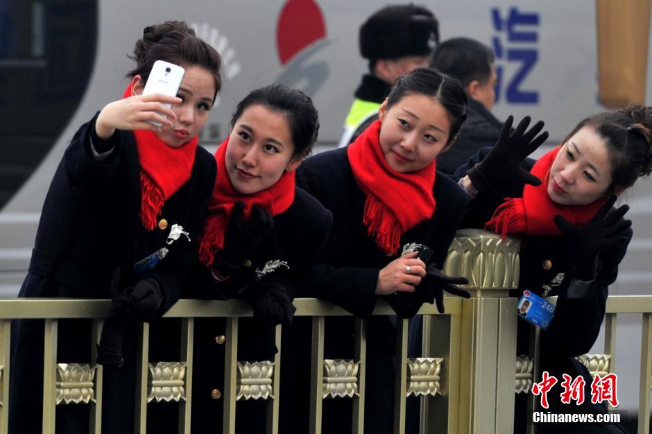 Le 3 mars, des hôtessess d'accueil de la 2ème session du 12e Comité National de la CCPPC prennent des selfies sur la place Tian'anmen. (CNS/ Jin Shuo)