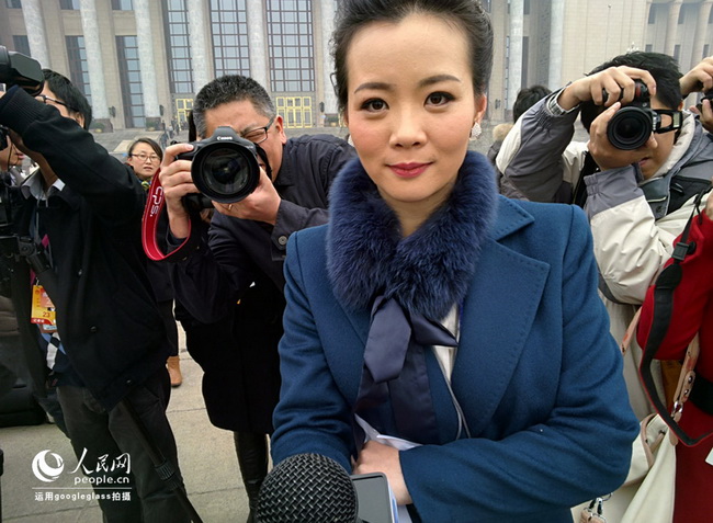 Une journaliste du Quotidien du Peuple en ligne devant les appareils-photo de la presse, photographiée par les Google Glass
