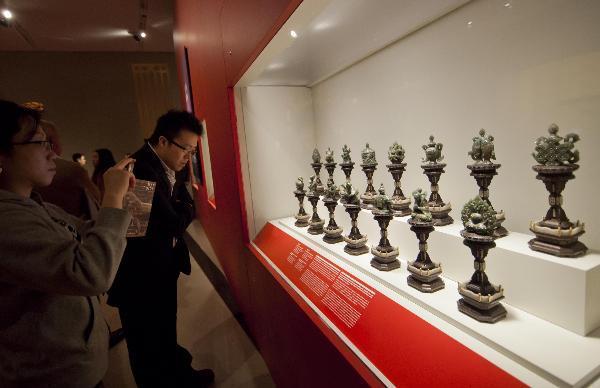 Des visiteurs regardent des trésors du Musée de la Cité Interdite au cours de la journée des médias de l'exposition "La Cité Interdite : l'intérieur de la Cour des empereurs de la Chine" au Musée royal de l'Ontario à Toronto, au Canada, le 5 mars 2014. [Photo/Xinhua]
