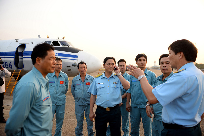 Un équipage de la force aérienne vietnamienne devant un avion de l'aéroport de Tan Son Nhat à Ho Chi Minh-Ville du Vietnam, le dimanche 9 Mars 2014. Ils vont bientôt rejoindre la zone maritime se trouvant entre le Vietnam et la Malaisie où le Boeing du vol MH370 aurait disparu.