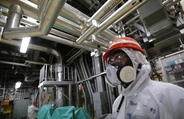 Un employé de la Tokyo Electric Power Co. (TEPCO) portant une tenue et un masque de protection inspecte la zone de la chambre de suppression située au sous-sol du bâtiment n° 5 du réacteur de la centrale.