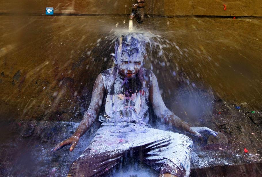 C'est l'heure de la douche, après avoir pris part aux célébrations du Festival des Couleurs, dans la ville indienne méridionale de Chennai, le 16 mars 2014.