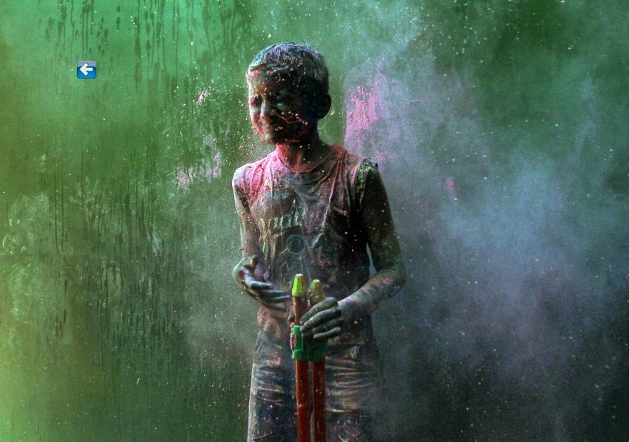Un jeune garçon dans une bataille de poudres de couleurs, lors des célébrations du Holi dans la ville indienne méridionale de Chennai, le 16 mars 2014. 