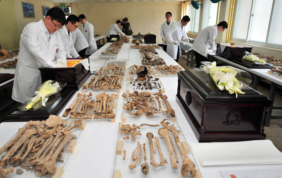 Des soldats sud-coréens enveloppent les dépouilles des soldats chinois lors d'un rite officiel pour la mise en bière, dans une base de l'armée sud-coréenne à Paju (nord de Séoul), le 17 mars 2014. 