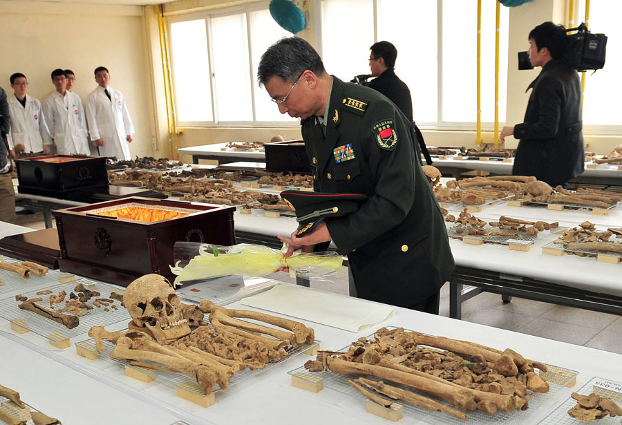 Un officier militaire chinois dépose des fleurs près de la dépouille d'un soldat chinois avant sa mise en cercueil, dans une base de l'armée sud-coréenne à Paju (nord de Séoul), le 17 mars 2014. 