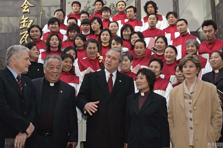 Le 20 novembre 2005, le président américain d'alors George W. Bush et son épouse posent avec des fidèles chinois après une messe à Beijing. 