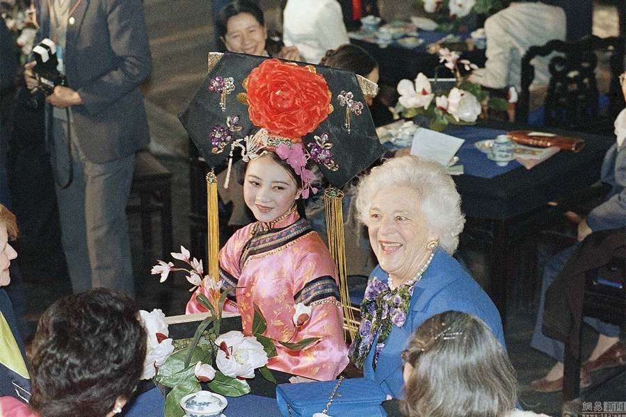 Le 26 février 1989, dans le palais du prince Gong à Beijing, Barbara Bush à côté d'une jeune fille qui présente la cérémonie du thé.