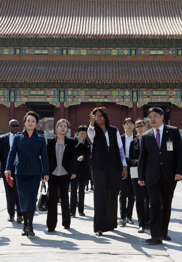 La première dame des États-Unis Michelle Obama (au centre) et Peng Liyuan (à gauche), l'épouse du président chinois Xi Jinping, visitent la Cité Interdite à Beijing, le 21 mars 2014.