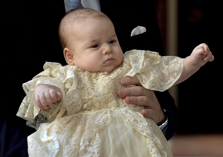 Le Prince William porte son fils, le Prince George alors qu'ils arrivent pour le baptême de son fils au palais St James à Londres, le 23 octobre 2013.