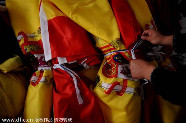 Les ouvrières de l'usine emballent les drapeaux nationaux des équipes qualifiées pour la Coupe du Monde qu'elles ont produits dans les locaux de la société Hanghzou Donghao Flag Co, dans la Province du Zhejiang, dans l'Est de la Chine, le 8 avril 2014. 