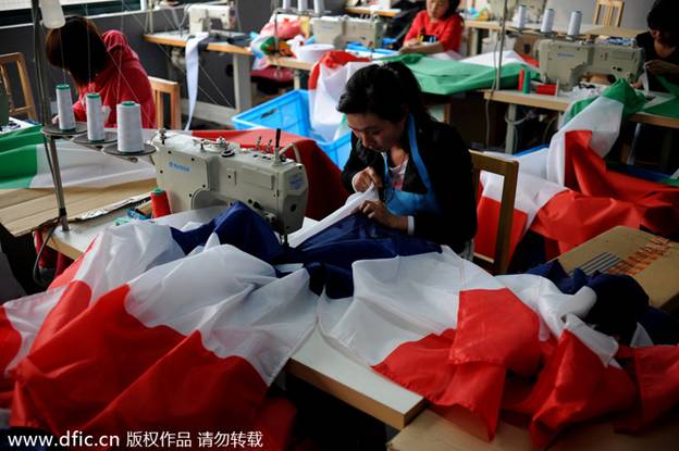Les ouvrières travaillent 24 heures sur 24 à faire les drapeaux nationaux des équipes qualifiées pour la Coupe du Monde afin de respecter l'échéance du 14 avril, dans les locaux de la société Hangzhou Donghao Flag Co, dans la Province du Zhejiang, en Chine de l'Est. Photo prise le 8 avril 2014.