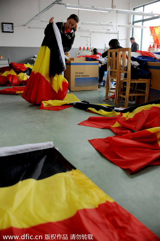 Des ouvrières contrôlent les drapeaux nationaux qu'elles ont produits dans les locaux de la société Hangzhou Donghao Flag Co, dans la Province du Zhejiang, en Chine de l'Est, le 8 avril 2014. 