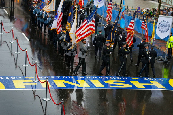 Des gardes défilent sur la ligne d'arrivée, à l'occasion d'une cérémonie marquant le premier anniversaire des attentats de l'édition 2013 du marathon de Boston (Massachusetts), le 15 avril 2014.