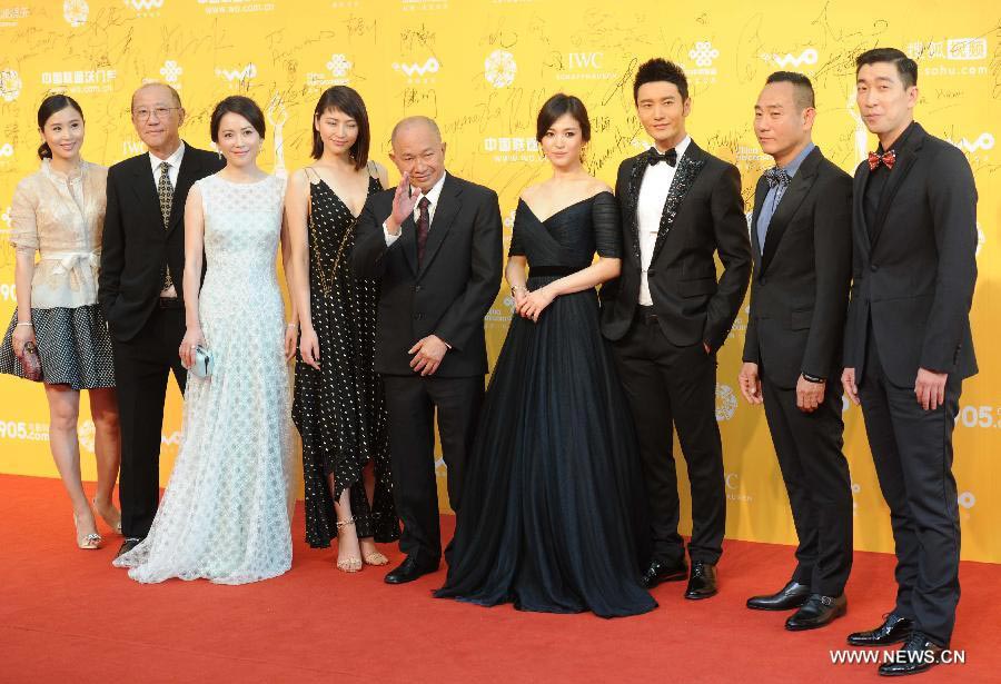 Le réalisateur John Woo (centre) prend la pose sur le tapis rouge avec les acteurs vedettes du film "The Crossing"