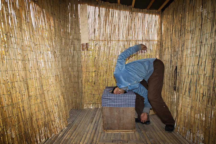 Tang Guanhua n'hésite pas à plonger sa tête dans la cuvette d'une toilette écologique pour montrer sa propreté.[Photo/qq.com]