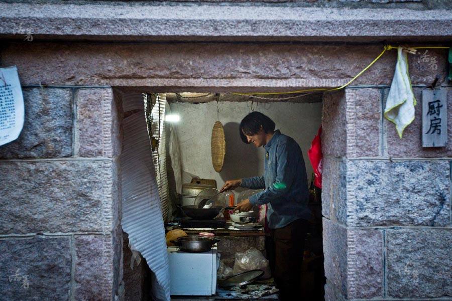 Tang Guan prépare un repas dans la cuisine de sa maison . Le couple a acheté de la farine et du riz, mais veille à un style de vie en complète autonomie.[Photo/qq.com]