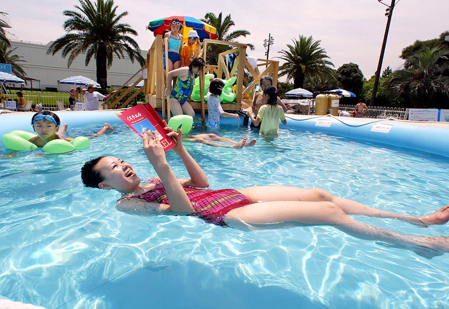 Le 27 juillet 2002, dans une piscine remplie d'eau de la Mer Morte à Tokyo au Japon, une femme s'adonne à la lecture en flottant sur l'eau. (Photo : Xinhua/AFP)
