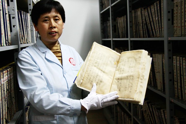 Un membre du personnel montre un volume de fichiers japonais, aux Archives de Changchun, la province chinoise du Jilin (nord du pays), le 22 avril  2014 [Photo: Song Wei/chinadaily.com.cn].