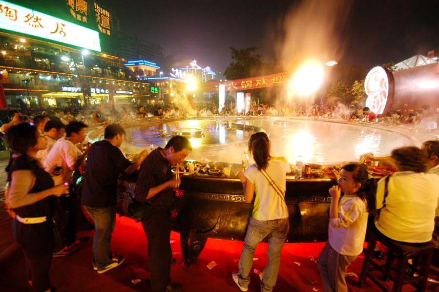 Des gens rassemblés  autour d'une fondue géante à Chongqing lors d'un festival de la gastronomie.