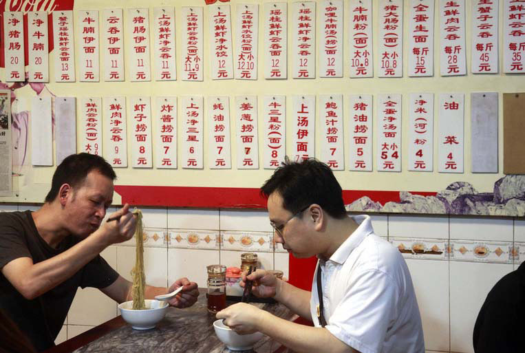 Des clients mangent des nouilles dans un restaurant local, qui est devenu populaire en raison de son apparition dans le documentaire « Le goût de la Chine ».