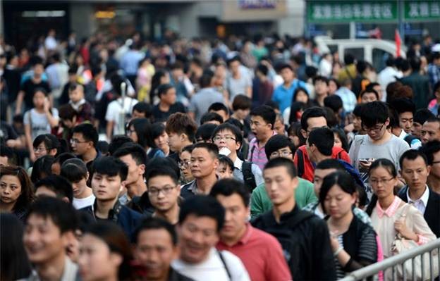 Les passagers font la queue pour passer les portiques avant de monter à bord d'un train à la gare de Nanchang, dans la Province du Jiangxi, le 1er mai. [Photo / Xinhua]