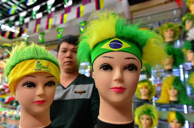Le propriétaire d'une boutique montre des perruques de couleurs vives à la Cité du Commerce International d'Yiwu, dans la Province du Zhejiang, dans l'Est de la Chine. Les perruques pour fans de football sont devenues un best-seller du plus grand marché de gros de petits objets de consommation courante du monde.