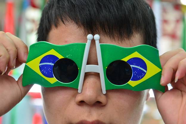 Un jeune garçon essaie sur des lunettes de soleil sur le thème de la prochaine Coupe du Monde au Brésil à la Cité du Commerce International d'Yiwu.