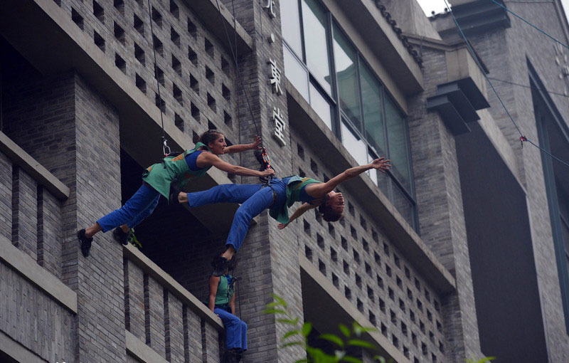 Deux danseurs exécutent un pas de deux sur le mur d'un bâtiment de la ville de Chongqing, le 9 mai 2014. 