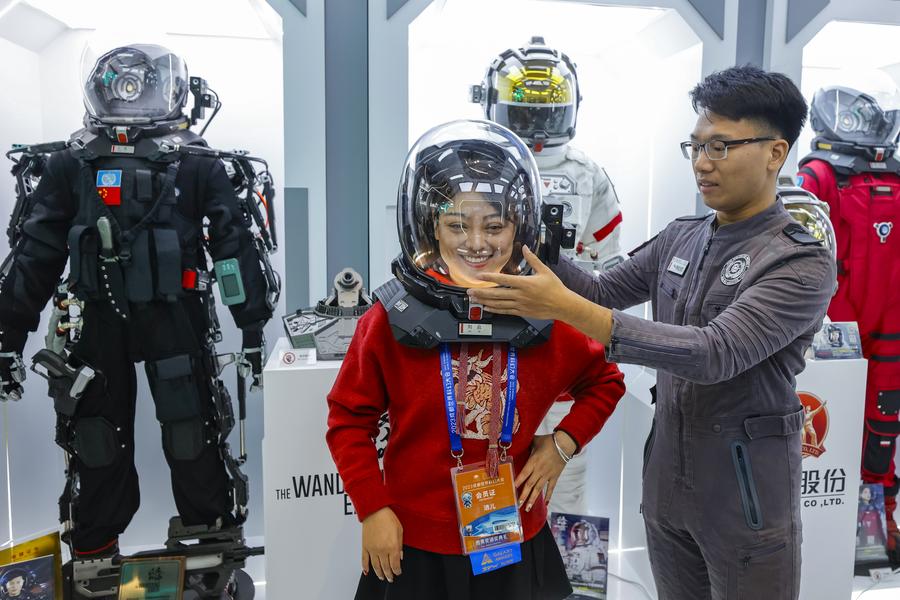 Une visiteuse essaye un casque spatial provenant du film "Terre errante", une superproduction de science-fiction chinoise, lors de la 81e Convention mondiale de la science-fiction (WorldCon), à Chengdu, dans la province du Sichuan, dans le sud-ouest de la Chine, le 18 octobre 2023. (Photo : Shen Bohan)